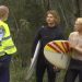 Policial conversa com surfistas na praia de Coffs Harbour, na Austrália — Foto: Australian Broadcasting Corporation/Via AP