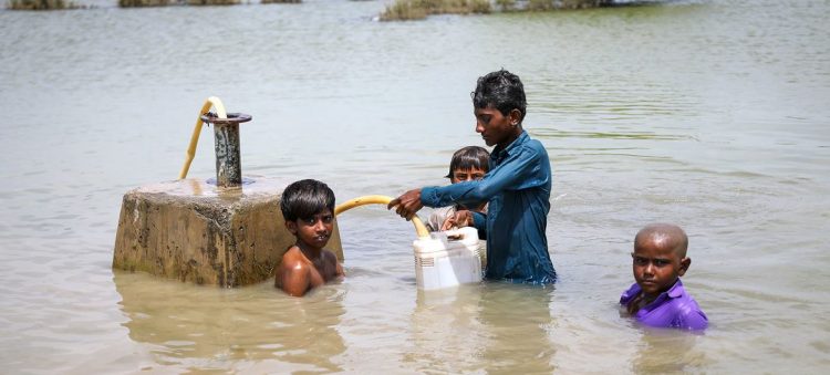 © Unicef:Asad Zaidi Meninos coletam água potável de uma linha de abastecimento de água durante enchente na província de Sindh, Paquistão