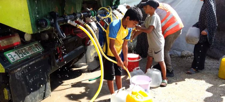 Crianças coletam água de um caminhão em um campo de deslocados em Gaza. Foto: ONU News
