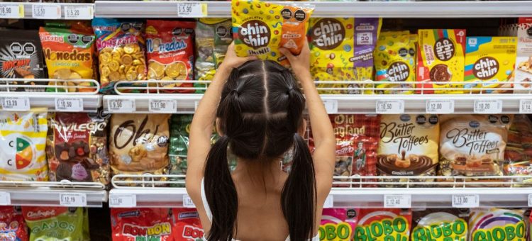 Uma jovem escolhe doces em um supermercado em Lima, Peru. Foto: UNICEF/Florence Goupil