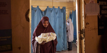 Uma mulher segura um bebê recém-nascido dentro da ala de trabalho de parto de um hospital no estado de Sokoto, Nigéria. Foto: UNICEF/David Boman