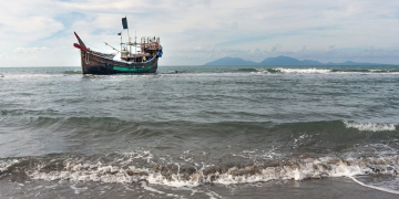 Um barco que transportou refugiados rohingya através do Mar de Andaman está ancorado ao largo da costa, após os refugiados desembarcarem em uma praia em Aceh, Indonésia, em 8 de janeiro de 2023. Foto: Acnur/ Kenzie Eagan