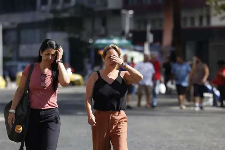 Pessoas se protegem do sol no centro da cidade em dia de calor no Rio de Janeiro. Foto: Fernando Frazão/Agência Brasil